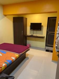 a room with a bed and a flat screen tv at Hotel Swagat Residency in Panhāla