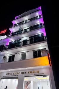 a tall white building with purple lights on it at Thành Trung Hotel Nghệ An in Vinh