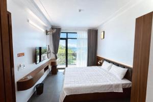 a bedroom with a bed and a large window at Thành Trung Hotel Nghệ An in Vinh