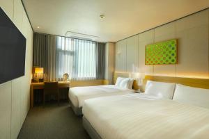 a hotel room with two beds and a desk at Orakai Cheonggyesan Hotel, BW Premier Collection in Seoul
