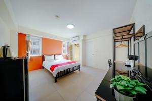 a bedroom with a bed and an orange wall at Salin Home Hotel Ramkhamhaeng in Bangkok