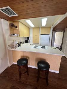 a kitchen with two stools and a counter with a stove at 305 On the Beach in Waianae
