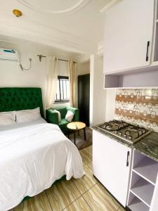 a small bedroom with a bed and a kitchen at Abu Dhabi CC Hotel in Limbe