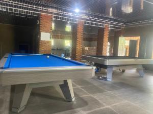 a pool table in a room with two tables at Askara Toba Cottage in Tuktuk Siadong