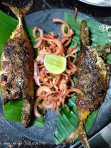 a plate of food with noodles and fish on a plate at Sukhad Home Stay in Gimvi