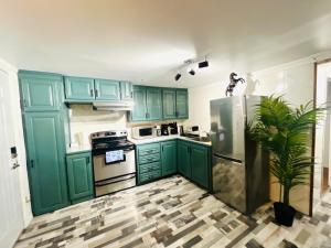 a kitchen with green cabinets and a stainless steel refrigerator at Linda inn - Entire Unit- Sleep 3- Sherbrooke in Sherbrooke +10 photos