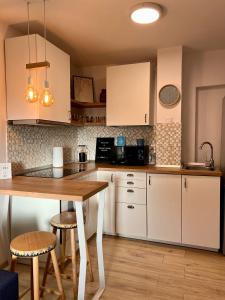 a kitchen with white cabinets and a wooden table at Transylvanian Nomad II in Cluj-Napoca