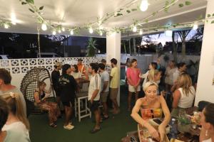 a crowd of people standing around a party in a marquee at Palms on Parker Backpackers in Maroochydore +40 photos