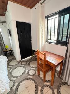 a room with a wooden bench and a window at Abu Dhabi CC Hotel in Limbe +5 photos