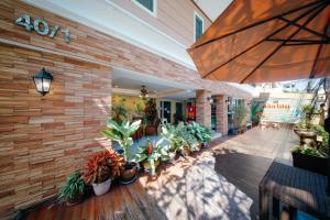 an outdoor patio with potted plants and an umbrella at Salin Home Hotel Ramkhamhaeng in Bangkok