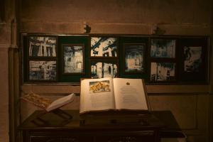 a book on a table with pictures on a wall at BrijRama Palace, Varanasi - By the Ganges in Varanasi
