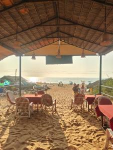 a beach with tables and chairs on the sand at Sea view Sun shine in Calangute