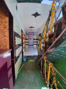 a corridor of a building with a green floor and stairs at JSRInn in Mathura