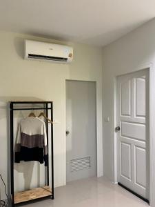 a room with a white wall with a ceiling fan at เดย์ อิน in Ban Nong Sua Chang