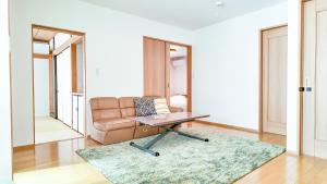 a living room with a couch and a laptop on a table at 9Stay市原 in Ichihara