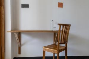 a wooden desk with a chair next to a wall at Beach House by Unrushed in Welhengoda