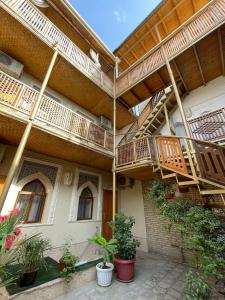 a building with balconies and potted plants in front of it at Hotel Naqsh-band Terrace in Bukhara