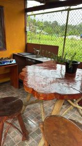 three wooden tables and chairs with a potted plant on them at Cabinas Cable Talamanca in Puerto Viejo