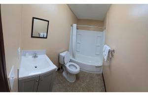 a bathroom with a white toilet and a sink at Candle Light Motel in Ozark