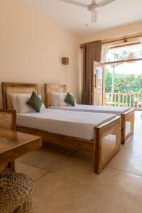 a bedroom with a large bed and a large window at Beach House by Unrushed in Welhengoda