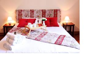 a bedroom with a large white bed with red pillows at Apartment Alloga in Belgrade