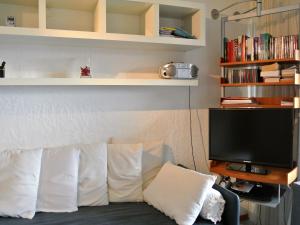 a living room with a couch with pillows and a television at Panorama in Villars-sur-Ollon
