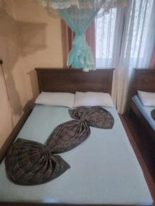 a bed with two large pillows on top of it at New Holiday Bungalow in Diyatalawa