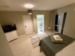 a bedroom with a bed and a flat screen tv at Heartbeat Cottage By Travel Lets Holiday Homes Letterkenny With Private Ensuite Rooms & Garden in Letterkenny
