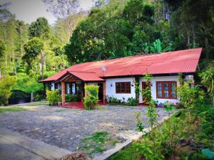 a small white house with a red roof at New Holiday Bungalow in Diyatalawa