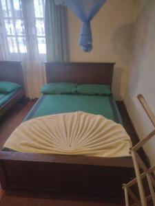 a bedroom with a bed with a bedspread on it at New Holiday Bungalow in Diyatalawa