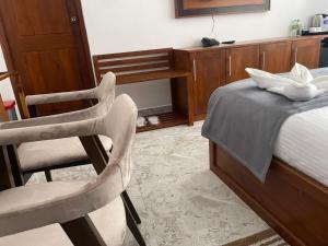 a bedroom with a bed with two chairs and a desk at lento suite hotel in Nikawatawana