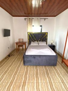 a bedroom with a bed and a flat screen tv at Abu Dhabi CC Hotel in Limbe