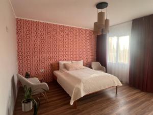 a bedroom with a bed and a pink wall at Viduma apartamenti in Ventspils