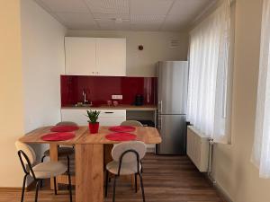 a kitchen with a wooden table with red plates on it at Viduma apartamenti in Ventspils