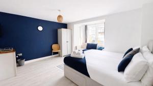 a bedroom with a blue accent wall and a bed at AMETHYST - 4br all with ensuite & parking in Cambridge