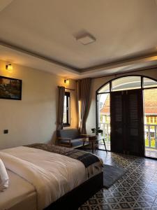 a bedroom with a bed and a chair and a window at The TARA PRABANG - Luangprabang in Luang Prabang