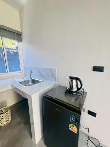 a small kitchen with a sink and a refrigerator at Blue Mountain Kamala Phuket in Kamala Beach