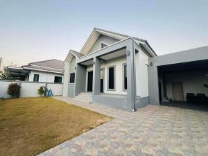 a white house with a large yard in front of it at SRE- JOY Holiday Home in Mae Sot in Mae Sot