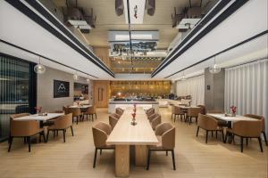 a restaurant with tables and chairs and a bar at 重庆西站站前广场亚朵酒店 in Chongqing