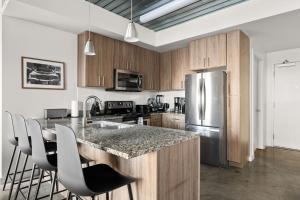 a kitchen with a granite counter top and stainless steel appliances at Lodgeur Midtown, Houston - close to Downtown & Texas Medical Center in Houston