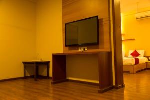 a living room with a flat screen tv on a table at Hotel Sri Sakthi in Tiruppūr