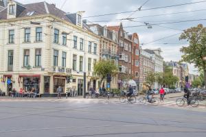 a group of people riding bikes down a city street at Hotel Plantage in Amsterdam