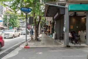 a busy city street with a street sign on the sidewalk at Cozy Corner Bangpho in Bang Su