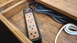 a remote control sitting on top of a wooden table at Cozy Corner Bangpho in Bang Su