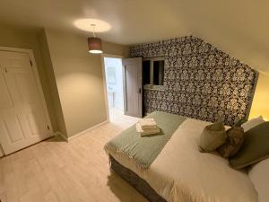 a bedroom with a bed with a patterned wall at Heartbeat Cottage By Travel Lets Holiday Homes Letterkenny With Private Ensuite Rooms & Garden in Letterkenny
