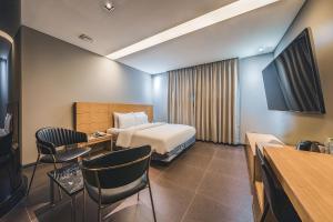 a hotel room with a bed and a table and chairs at Hotel Hills in Paju