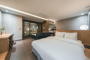 a bedroom with a large bed and a bathroom at Hotel Hills in Paju