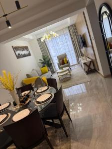 a dining room and living room with a table and chairs at Zen Haven Lavington in Nairobi