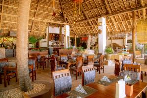 a restaurant with tables and chairs and a bar at Boutique Hotel Matlai in Michamvi