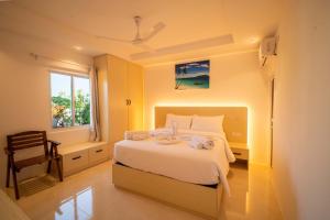 a bedroom with a bed with a window and a chair at Vilu Himmafushi in Himmafushi